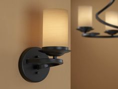 a wall light that is on the side of a wall with three lights in it