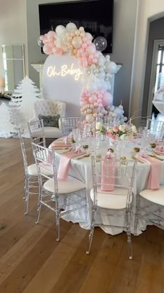 a table set up with pink and white decorations