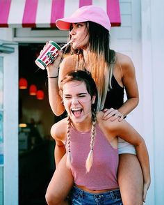 two young women having fun with each other while one holds onto the back of another woman