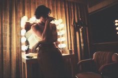 a woman standing in front of a mirror brushing her teeth