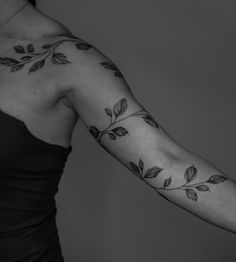 a woman's arm with leaves on it