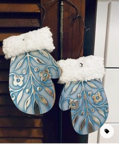 two blue and white mittens hanging from a hook