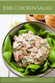 chicken salad in a bowl with lettuce leaves on the side and croissants next to it