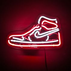 a neon sign with a shoe on it's side and the word nike written in white