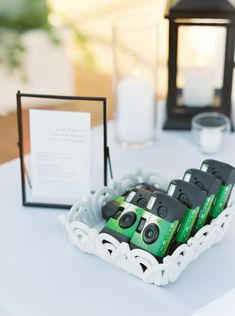 there are four cameras on the table next to some candles and a card in a holder