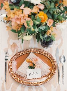 a place setting with flowers and napkins