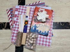 an assortment of crafting supplies laid out on top of a checkered table cloth