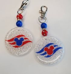 two mickey mouse keychains with red, white and blue designs on them are shown