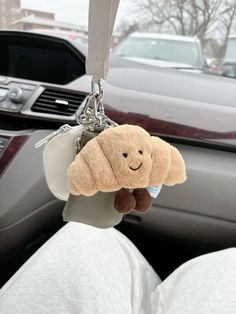 a stuffed animal hanging from a car keychain in the passenger's seat