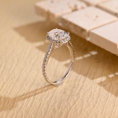 a diamond ring sitting on top of a wooden table next to a piece of wood