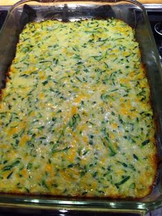 a casserole dish with cheese and spinach in it sitting on the stove