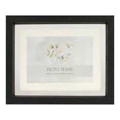 a white and black frame with flowers on the wall above it is an inscription that reads photo frame