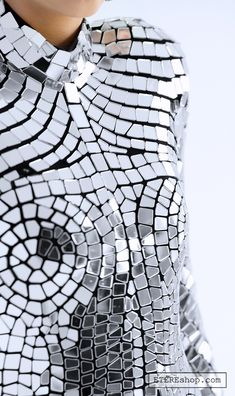 a close up of a woman's dress made out of silver and black squares