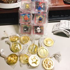 some gold and silver buttons sitting on top of a white table next to each other