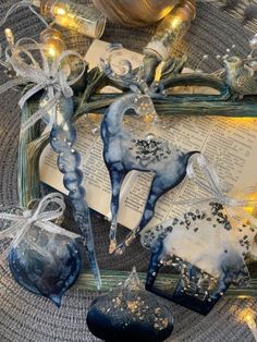 some blue and white ornaments on top of an open book with lights in the background