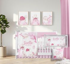 a baby crib bedding set with pink sea animals and turtle prints on the wall