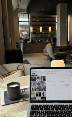 an open laptop computer sitting on top of a wooden table next to a cup of coffee