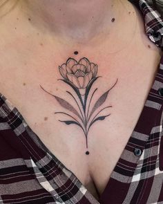 a woman's chest with a flower tattoo on her left side and an arrow in the middle