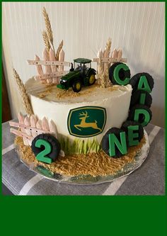 there is a cake that has been decorated with farm animals and tractor logos on it