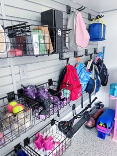 several baskets and bags are hanging on the wall next to each other in an organized room