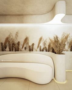 a white couch sitting in front of a wall with plants on it's side