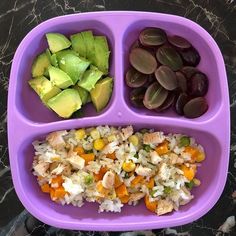 a purple plate topped with rice, fruit and veggies next to an avocado