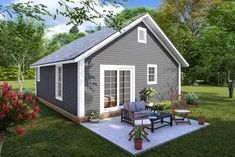 a small gray house sitting on top of a lush green field