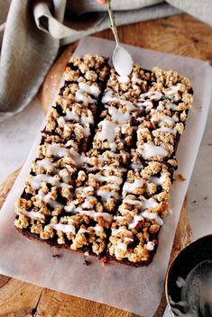 a person is spooning icing from a dessert on a piece of parchment paper