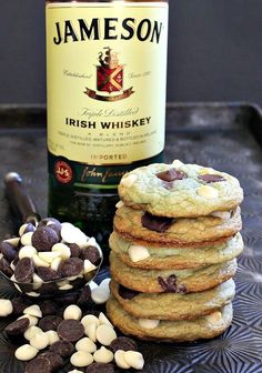 a stack of cookies next to a bottle of wine and some marshmallows