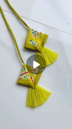 two yellow tassels hanging from a string on top of a white countertop