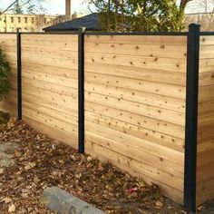 a wooden fence with black metal posts