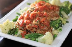 a white plate topped with meat and veggies