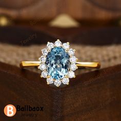 a blue and white diamond ring sitting on top of a wooden box