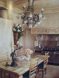 a dining room table with chairs and vases on top of it in front of an oven