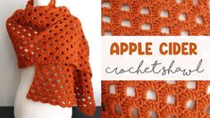 an orange crocheted shawl on top of a white mannequin