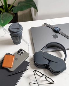 an apple laptop, headphones and other items on a table