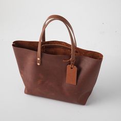 Tan Kodiak Market Tote | Large Leather Tote Bag made in the USA – KMM & Co. Brown Textured Vegetable Tanned Leather Bags, Brown Textured Vegetable Tanned Leather Satchel, Brown Textured Leather Satchel, Brown Oiled Leather Bag With Smooth Grain, Classic Bags With Leather Strap In Vegetable Tanned Leather, Classic Bag With Leather Strap In Vegetable Tanned Leather, Pebbled Leather Bags For Everyday Use, Pebbled Leather Bag With Leather Backing For Daily Use, Tote Bag With Leather Handles In Oiled Leather