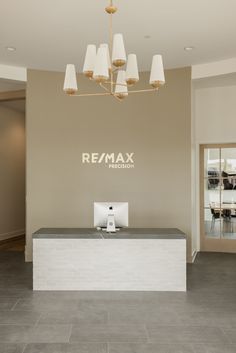 an office lobby with a desk and chandelier