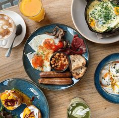 an assortment of breakfast foods on blue plates