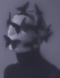 a man with many birds on his head in black and white photo, taken from the neck down