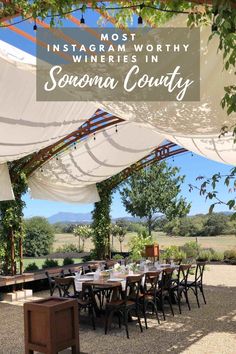 an outdoor dining area with tables and chairs under a white canopy that says instagram worthy wineries in sonoma county