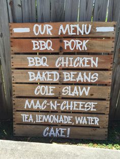 a wooden sign that says our menu for barbecue pork, bbq chicken, baked beans, cole slaw mac n cheese tea lemonade water cake