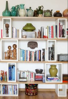 a shelf filled with lots of books and vases on top of eachother