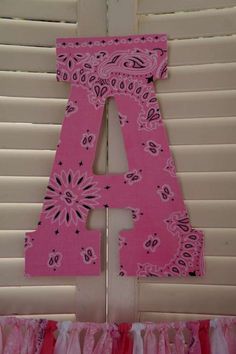 the letters are made out of pink paper and decorated with paisley designs, along with ruffles