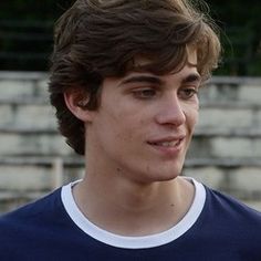 a young man in a blue shirt holding a white frisbee