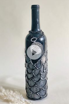 a bottle with chains around it sitting on a white surface