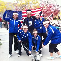 a group of people that are standing in the street with some baseball bats and an american flag