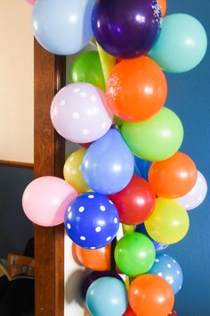 a bunch of balloons hanging from the side of a door