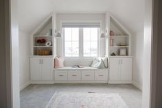 a window seat in the corner of a room with built - in bookshelves