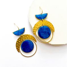 These statement dangle earrings are made from hand casted eco friendly resin with alcohol ink.  All of the components are brass apart from the ear wire which is nickel free gold plated so they're perfect for sensitive skin.  Measuring approximately 4cm width x 7.5cm drop length, you don't need to worry about them being heavy...as resin is lightweight they're super comfortable.  ❤️ Your jewellery will arrive on a presentation card and wrapped in tissue. If your sending as a gift and want me to include a note from you, on plain card, just leave a message at checkout. If you'd prefer your message on a cute birthday card they're available for £2, here's the link - https://www.etsy.com/uk/listing/1128179895/birthday-card-available-when-bought-with?ref=shop_home_active_1&frs=1 Gift wrapping also Blue Cadmium-free Drop Earrings, Modern Blue Brass Earrings, Blue Brass Dangle Earrings, Mystical Moon Shaped Brass Earrings, Festival Moon-shaped Brass Earrings, Celestial Moon-shaped Brass Earrings, Bohemian Blue Moon-shaped Earrings, Oversized Earrings, Presentation Cards